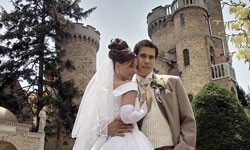 Ein Brautpaar mit einer Burg als Hochzeitslocation.