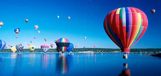 Heissluftballons spiegeln sich in einem See