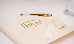 Ein Hochzeitsgästebuch mit Stift liegt für die Gäste bereit.